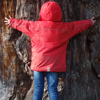 Kind umarmt einen Baum: Natur erleben pur